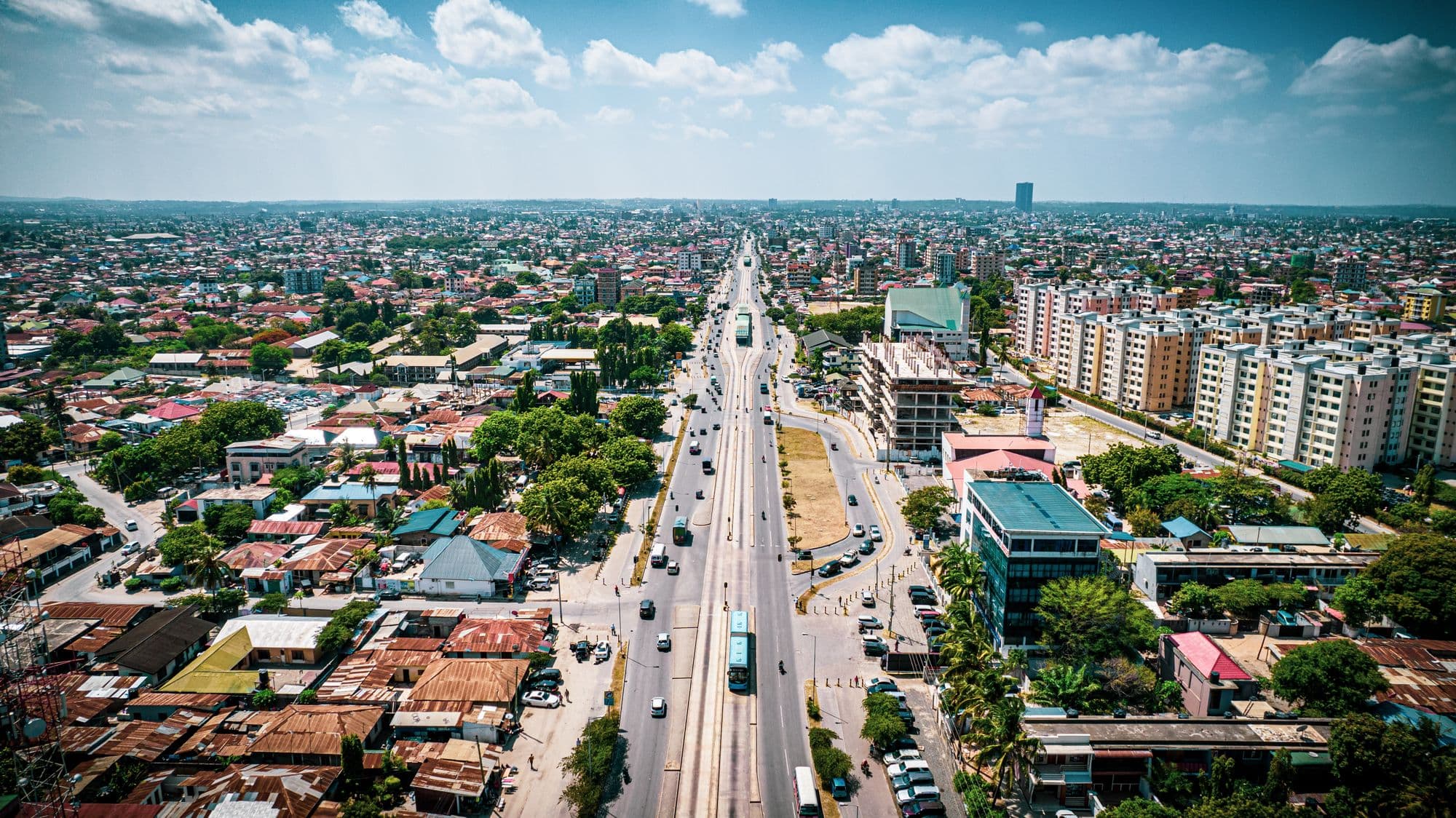 Aerial view of a main road running through Dar es Salaam, lined with homes and offices